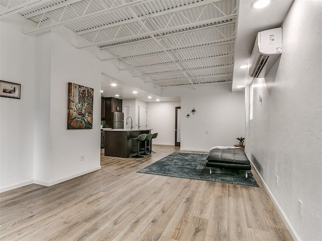 931 NW 7th St Unit 104, Oklahoma City, OK 73106 - sitting room with light wood-style floors, a wall mounted AC, and recessed lighting