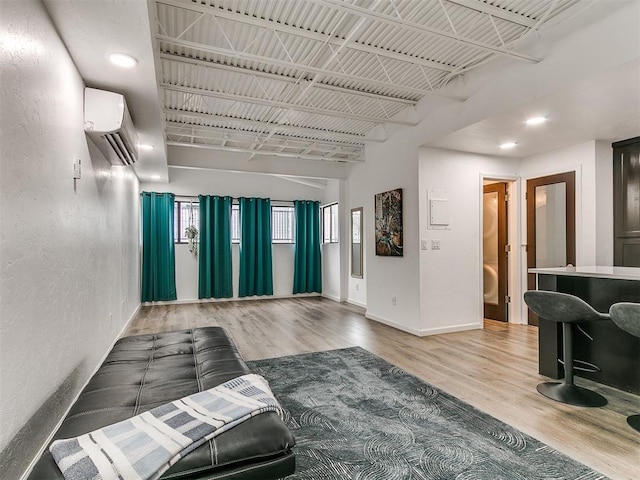 931 NW 7th St Unit 104, Oklahoma City, OK 73106 - living area with a wall mounted air conditioner, wood finished floors, and a textured wall
