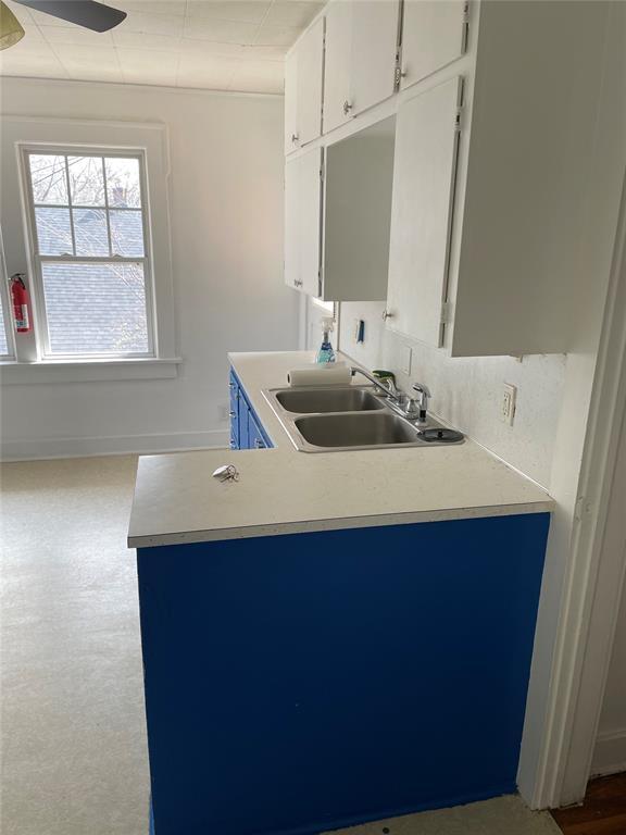 128 W Ridgewood St, Shawnee, OK 74801 - kitchen with a sink, white cabinetry, light countertops, and a peninsula