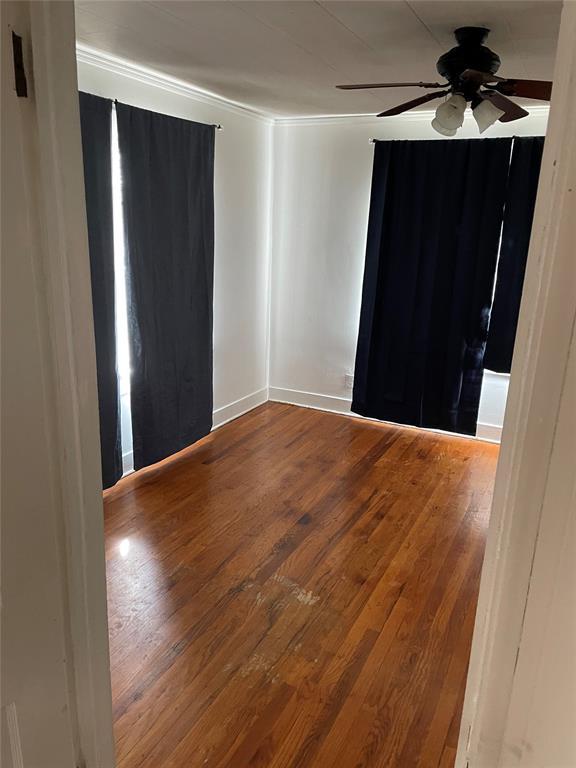 128 W Ridgewood St, Shawnee, OK 74801 - empty room featuring wood finished floors, ceiling fan, baseboards, and ornamental molding