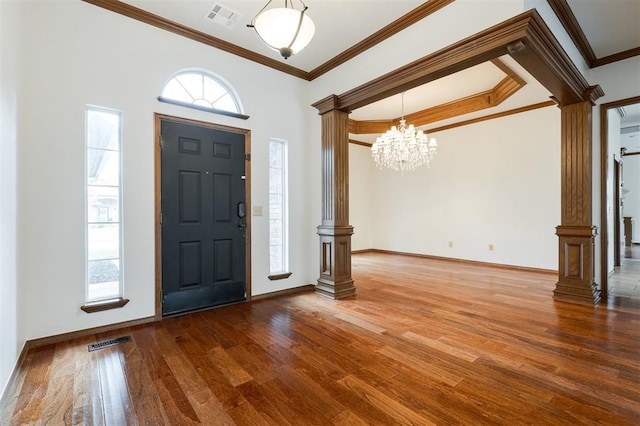 2613 NW 159th St, Edmond, OK 73013 - entrance foyer featuring decorative columns, wood finished floors, crown molding, a chandelier, and baseboards