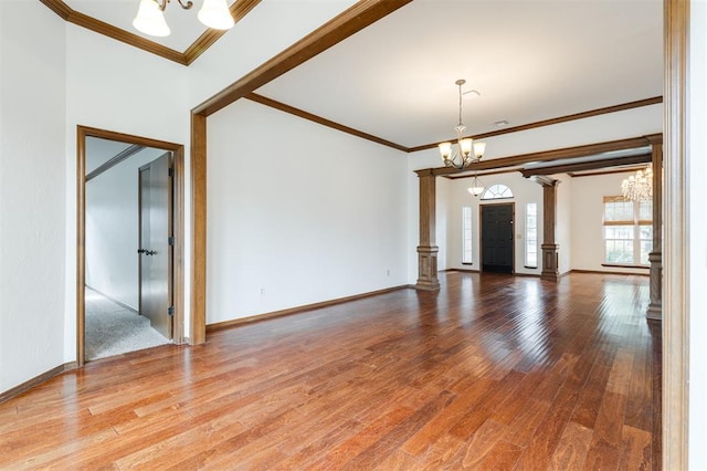 2613 NW 159th St, Edmond, OK 73013 - unfurnished room with a chandelier, ornate columns, wood finished floors, and ornamental molding