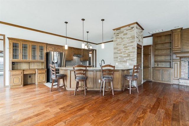 2613 NW 159th St, Edmond, OK 73013 - kitchen with stainless steel fridge with ice dispenser, ornamental molding, light wood finished floors, a peninsula, and tasteful backsplash