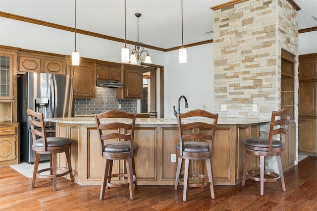 2613 NW 159th St, Edmond, OK 73013 - kitchen with stainless steel refrigerator with ice dispenser, crown molding, backsplash, a peninsula, and light wood-type flooring