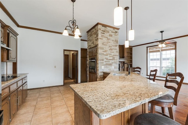 2613 NW 159th St, Edmond, OK 73013 - kitchen with a sink, stainless steel oven, a kitchen bar, ornamental molding, and black electric cooktop