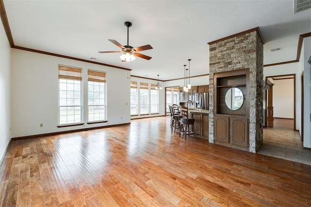 2613 NW 159th St, Edmond, OK 73013 - living area with light wood-style floors, a ceiling fan, ornamental molding, and baseboards