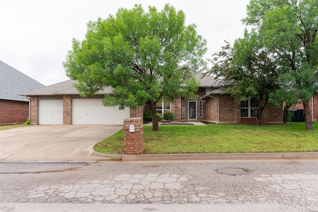 2613 NW 159th St, Edmond, OK 73013 - view of property hidden behind natural elements featuring a garage, driveway, a front yard, and brick siding