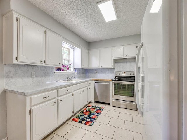 332 Crest Ln, Noble, OK 73068 - kitchen featuring appliances with stainless steel finishes, a textured ceiling, white cabinets, and tasteful backsplash