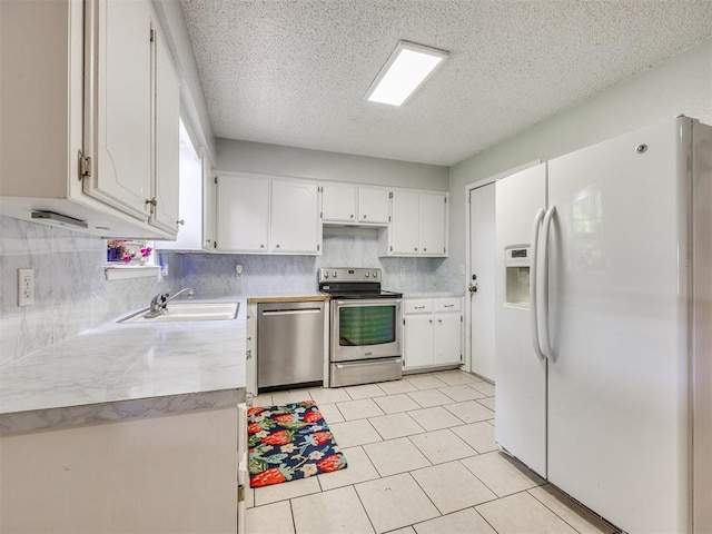 332 Crest Ln, Noble, OK 73068 - kitchen with stainless steel appliances, light countertops, white cabinets, decorative backsplash, and a textured ceiling