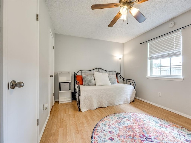 332 Crest Ln, Noble, OK 73068 - bedroom with light wood finished floors, a textured ceiling, and a ceiling fan