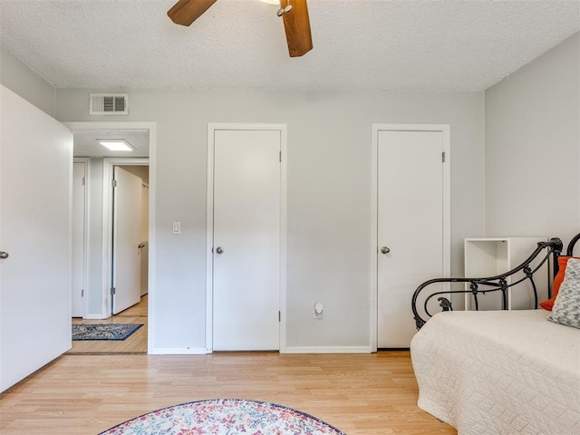 332 Crest Ln, Noble, OK 73068 - bedroom with light wood-style floors, a textured ceiling, and ceiling fan