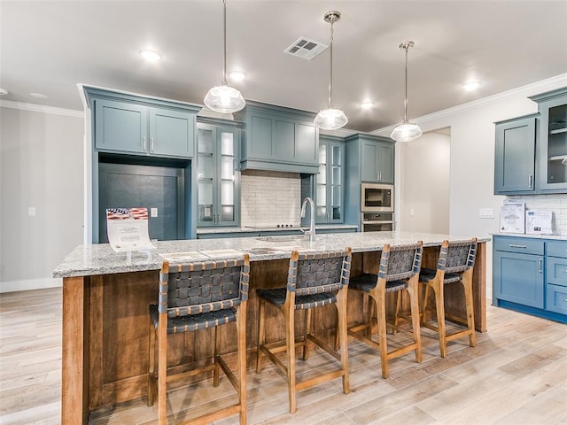 12825 Painted Sky, Edmond, OK 73007 - kitchen with appliances with stainless steel finishes, crown molding, tasteful backsplash, a kitchen breakfast bar, and light wood-type flooring