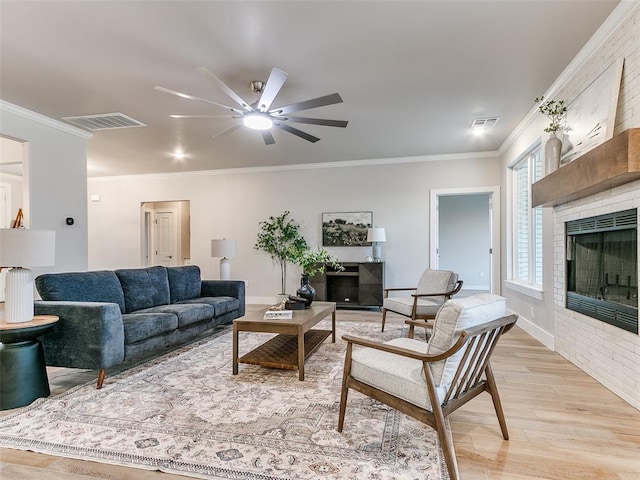 12825 Painted Sky, Edmond, OK 73007 - living room with a fireplace, light wood-style floors, ceiling fan, ornamental molding, and baseboards