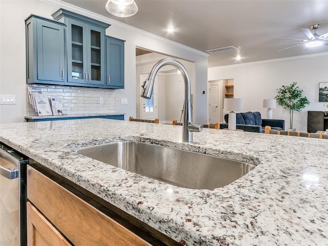 12825 Painted Sky, Edmond, OK 73007 - kitchen with a sink, blue cabinets, crown molding, glass insert cabinets, and light stone countertops