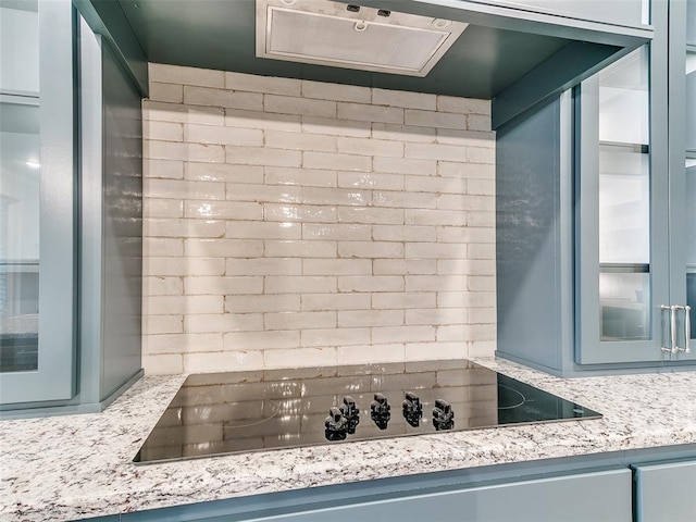 12825 Painted Sky, Edmond, OK 73007 - kitchen with black electric cooktop, glass insert cabinets, and blue cabinetry