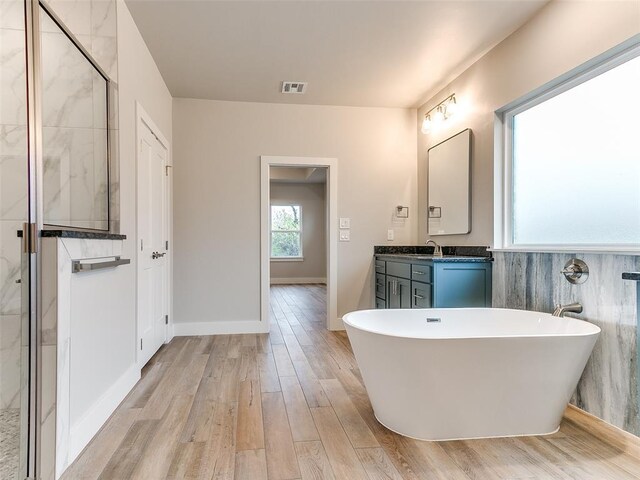 12825 Painted Sky, Edmond, OK 73007 - full bath with a freestanding tub, vanity, wood finished floors, and a stall shower
