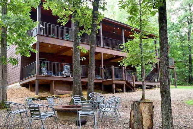 250 Almond Ln, Broken Bow, OK 74728 - back of property with an outdoor fire pit, stairs, a wooden deck, and a patio area