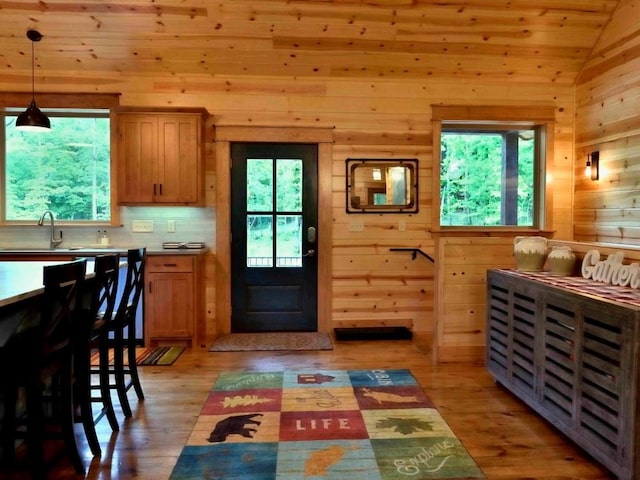 250 Almond Ln, Broken Bow, OK 74728 - kitchen with wooden walls, healthy amount of natural light, light wood-style floors, decorative light fixtures, and vaulted ceiling