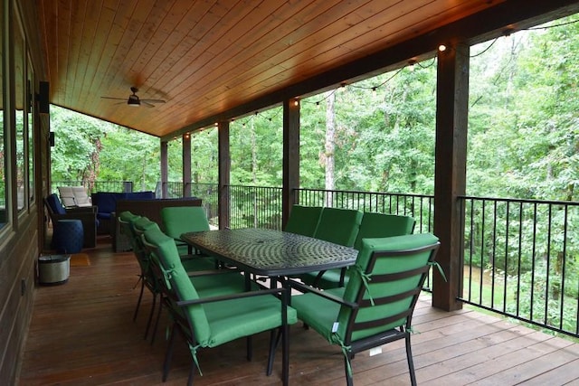 250 Almond Ln, Broken Bow, OK 74728 - wooden terrace featuring outdoor dining space, ceiling fan, and a view of trees