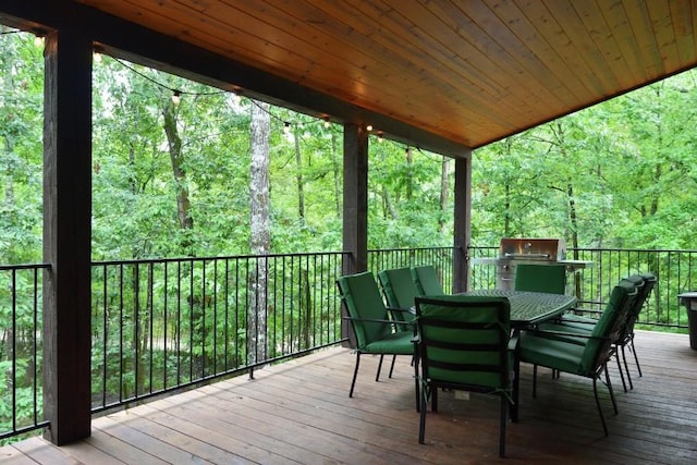 250 Almond Ln, Broken Bow, OK 74728 - wooden terrace with outdoor dining area, a view of trees, and area for grilling