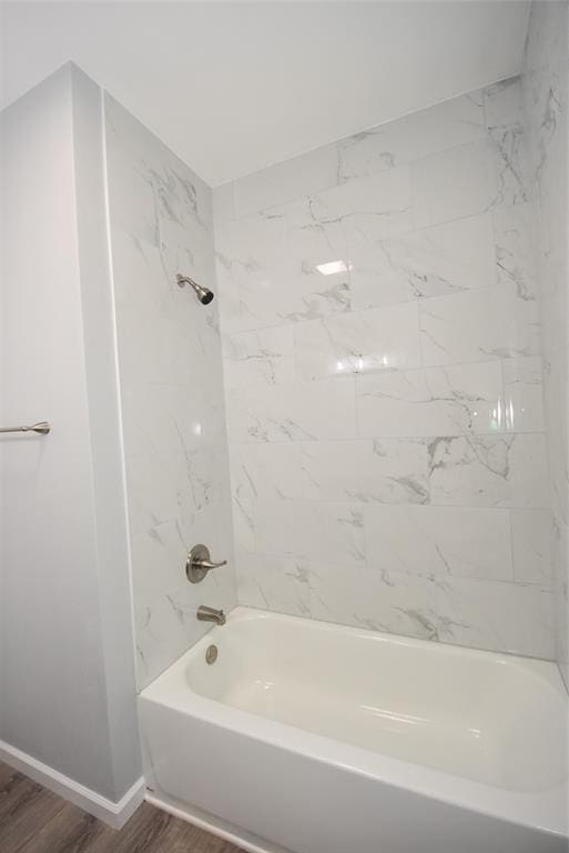 411 W Highland St, Shawnee, OK 74801 - bathroom with wood finished floors, bathtub / shower combination, and baseboards
