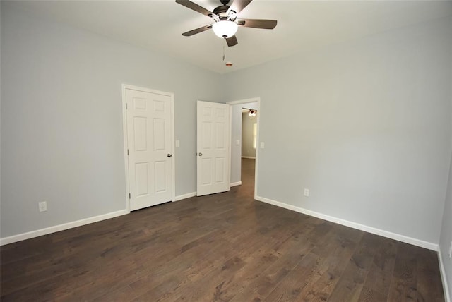 411 W Highland St, Shawnee, OK 74801 - unfurnished bedroom with baseboards, dark wood-type flooring, and a ceiling fan