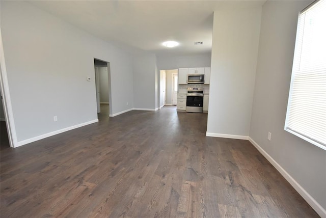 411 W Highland St, Shawnee, OK 74801 - unfurnished living room featuring dark wood-style floors and plenty of natural light