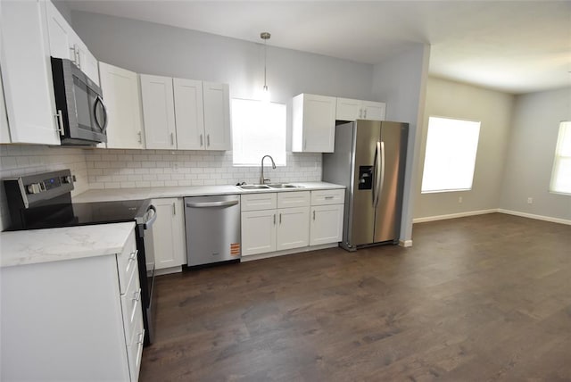 411 W Highland St, Shawnee, OK 74801 - kitchen featuring appliances with stainless steel finishes, white cabinets, decorative backsplash, dark wood-style floors, and plenty of natural light