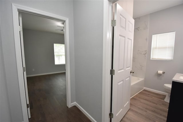 411 W Highland St, Shawnee, OK 74801 - bathroom featuring vanity, wood finished floors, washtub / shower combination, and a ceiling fan