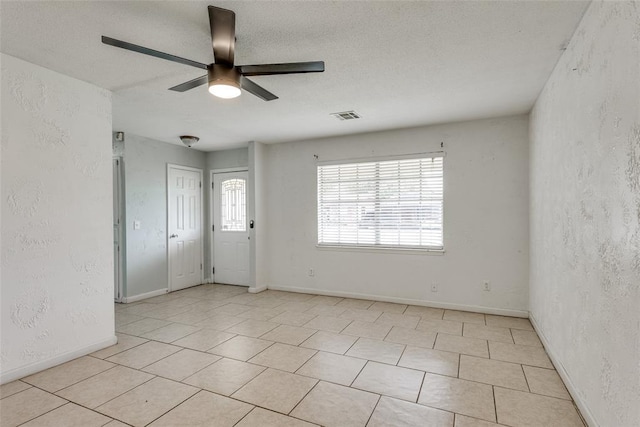 601 Woodland Way, Oklahoma City, OK 73127 - unfurnished room featuring a ceiling fan, a textured wall, and light tile patterned flooring
