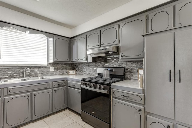 601 Woodland Way, Oklahoma City, OK 73127 - kitchen with stainless steel range with gas stovetop, under cabinet range hood, gray cabinetry, and decorative backsplash