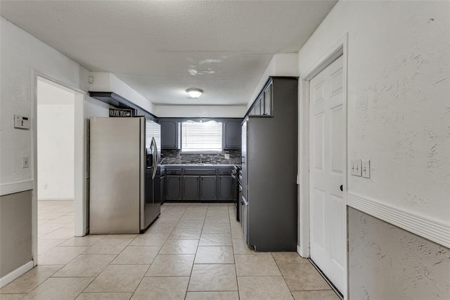 601 Woodland Way, Oklahoma City, OK 73127 - kitchen featuring stainless steel fridge, light tile patterned floors, a textured ceiling, and decorative backsplash