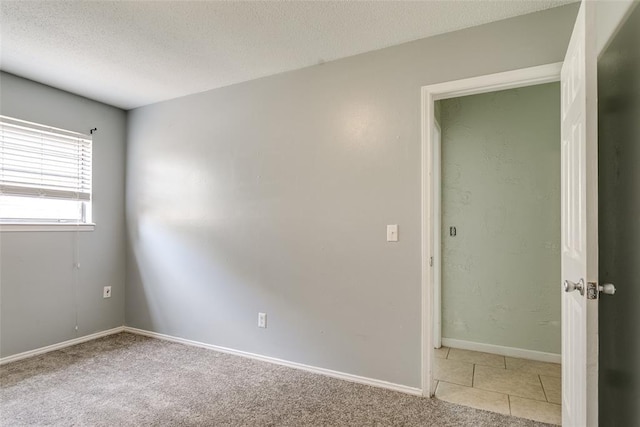 601 Woodland Way, Oklahoma City, OK 73127 - empty room with a textured ceiling, light tile patterned flooring, and light colored carpet