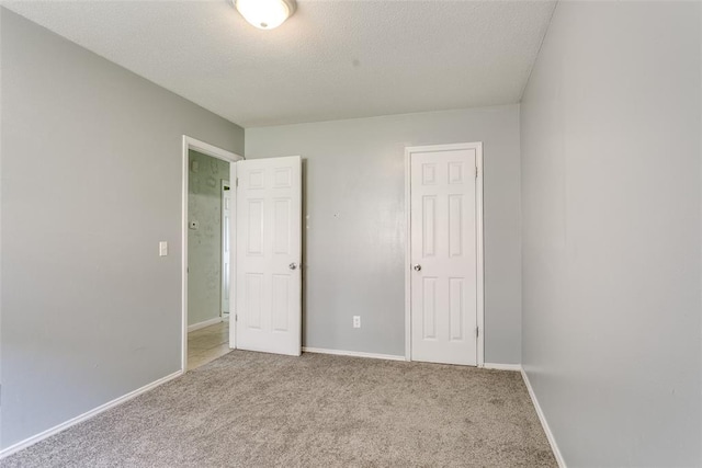 601 Woodland Way, Oklahoma City, OK 73127 - unfurnished bedroom featuring carpet flooring and a textured ceiling