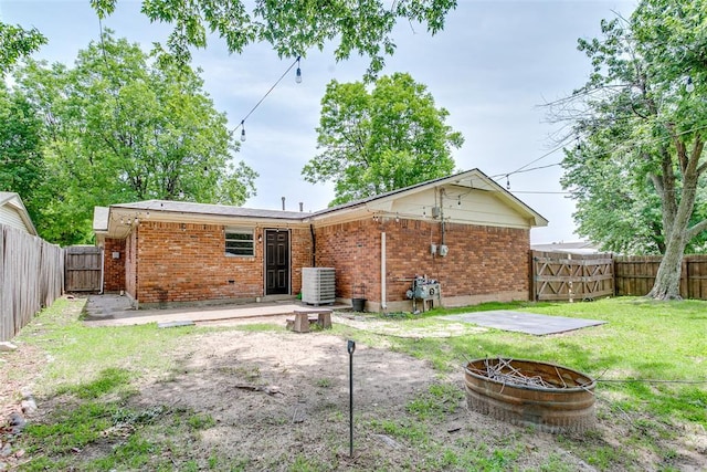 601 Woodland Way, Oklahoma City, OK 73127 - rear view of property with an outdoor fire pit, a gate, brick siding, a fenced backyard, and a patio