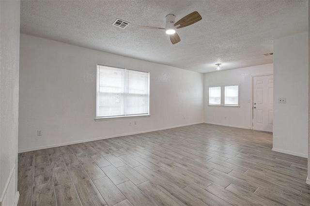 1633 SE 52nd St, Oklahoma City, OK 73129 - unfurnished room featuring wood finished floors, ceiling fan, a textured ceiling, and baseboards
