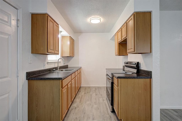1633 SE 52nd St, Oklahoma City, OK 73129 - kitchen featuring stainless steel electric range, a sink, light wood-style flooring, dark countertops, and a textured ceiling