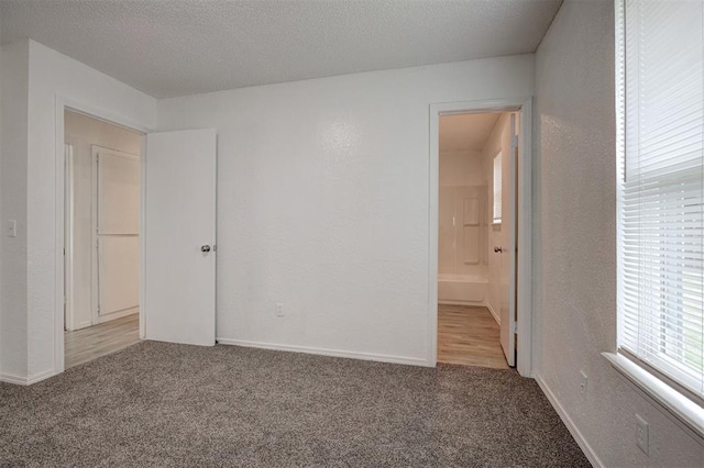 1633 SE 52nd St, Oklahoma City, OK 73129 - unfurnished bedroom featuring carpet flooring, a textured wall, a textured ceiling, baseboards, and ensuite bathroom