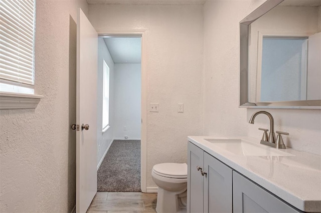1633 SE 52nd St, Oklahoma City, OK 73129 - bathroom with vanity, a textured wall, toilet, and wood finished floors