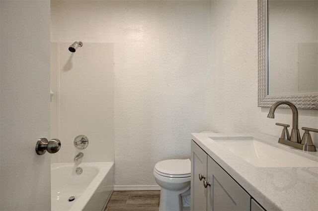 1633 SE 52nd St, Oklahoma City, OK 73129 - bathroom with vanity, toilet, wood finished floors, washtub / shower combination, and baseboards