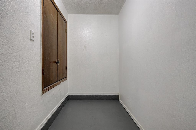 1633 SE 52nd St, Oklahoma City, OK 73129 - empty room featuring baseboards, concrete flooring, a textured ceiling, and a textured wall