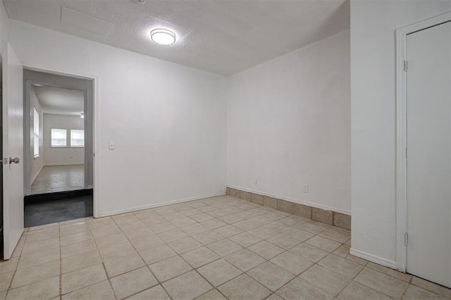 1633 SE 52nd St, Oklahoma City, OK 73129 - empty room featuring a textured ceiling, light tile patterned flooring, and baseboards