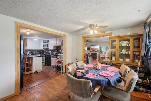 1001 N Pine St, Midwest City, OK 73130 - dining room featuring wood finished floors, ceiling fan, and a textured ceiling