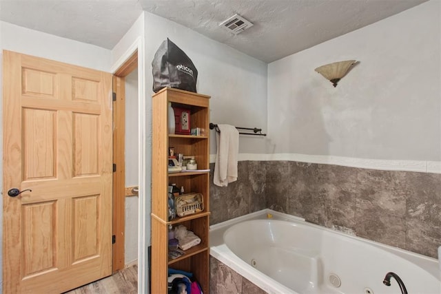 1001 N Pine St, Midwest City, OK 73130 - full bathroom with a whirlpool tub and wood finished floors