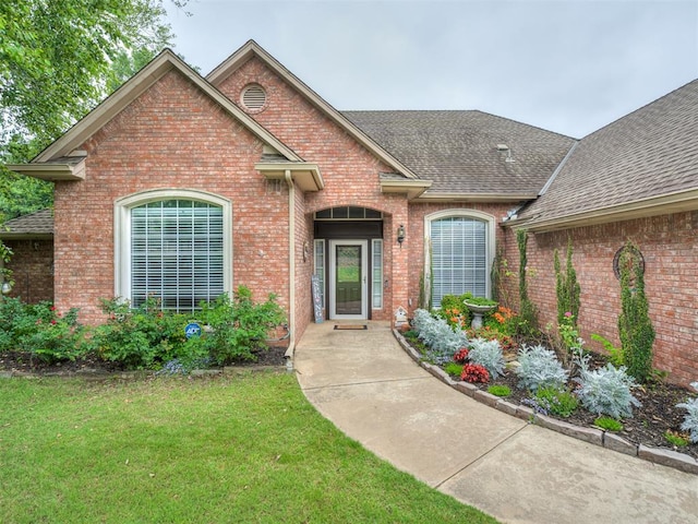 2500 Huntwick Dr, Edmond, OK 73034 - view of front of property with roof with shingles, a front lawn, and brick siding