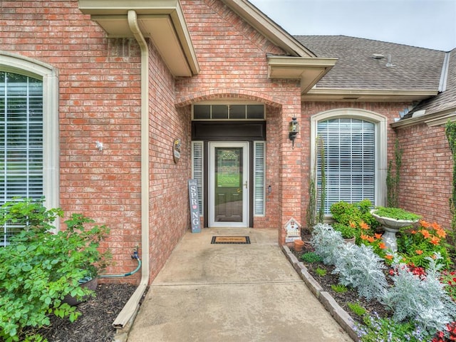 2500 Huntwick Dr, Edmond, OK 73034 - view of exterior entry featuring brick siding and roof with shingles