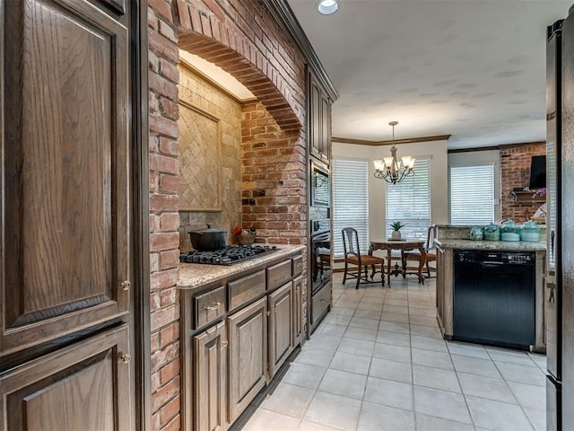 2500 Huntwick Dr, Edmond, OK 73034 - kitchen featuring black appliances, light tile patterned floors, a chandelier, brick wall, and decorative light fixtures