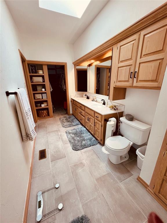 11700 Hackney Ln, Yukon, OK 73099 - bathroom featuring toilet, double vanity, and a spacious closet