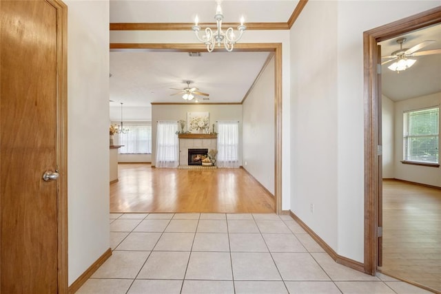 1908 Riviera Dr, Tuttle, OK 73089 - unfurnished living room with ceiling fan, a chandelier, a tiled fireplace, light wood finished floors, and ornamental molding