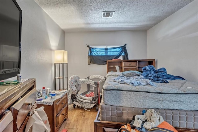 2119 Pearson Dr, Midwest City, OK 73110 - bedroom with light wood-type flooring and a textured ceiling